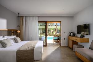 a hotel room with a bed and a tv and a couch at Stella Palace Aqua Park Resort in Hersonissos