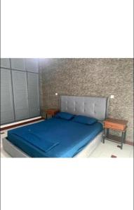 um quarto com uma cama azul e uma mesa em Bel appartement à Ifrane em Ifrane