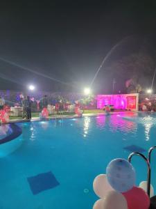 una piscina por la noche con una fuente en Blue Diamond Resort & Hotel, en Muzaffarpur
