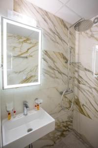 a bathroom with a sink and a mirror at Hotel Coop - Kiten in Kiten