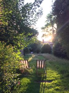 dos bancos sentados en el césped en un jardín en Le Jardin des Lys en Saint-Léonard-de-Noblat