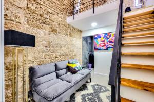 un salon avec un canapé et un mur de briques dans l'établissement David & Yossef Luxury Rentals - Tel Aviv House Residence, à Tel Aviv