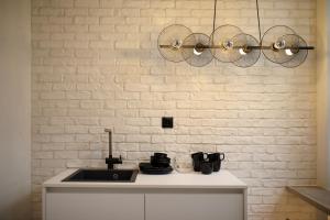 a kitchen with a sink and a white brick wall at CityBee in Athens