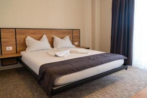 1 dormitorio con 1 cama grande con almohadas blancas en ALYA Sea Escape Costinesti - parcare gratuita en Costinesti