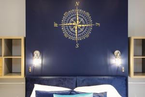 a bedroom with a blue wall with a clock on it at Cormorant PLACE LUXURY PAD in Portsmouth