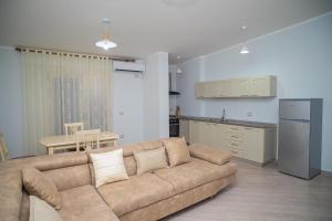 ein Wohnzimmer mit Sofa und eine Küche in der Unterkunft Vila Pulo in Tragjas