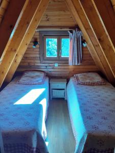two beds in the attic of a log cabin at chalets cocody in Jausiers