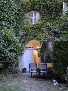 twee stoelen en een tafel voor een gebouw bij Le Chateau in Évian-les-Bains