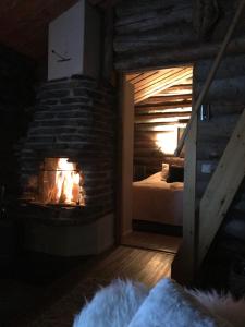 a bedroom with a fireplace with a bed in it at Iso-Syötteen Kelokolo Soarvesalvu in Syöte +19 photos