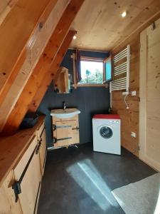 a bathroom with a washing machine in a cabin at chalets cocody in Jausiers