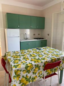 una cucina con tavolo e tovaglia gialla e verde di Alborea a Punta Braccetto