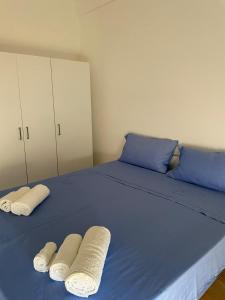 un letto blu con due asciugamani bianchi sopra di Alborea a Punta Braccetto