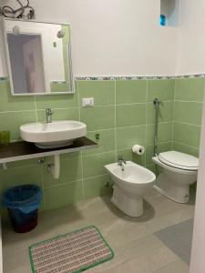 bagno con lavandino, servizi igienici e specchio di Alborea a Punta Braccetto