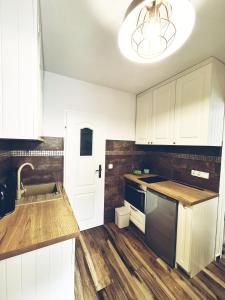 a kitchen with white cabinets and a sink at Apartamencik Nad Jeziorem Dzwon Marcinkowo 51 - 2 in Mrągowo