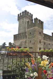 a castle with a bunch of flowers in front of it at Hotel Grifone in Sirmione