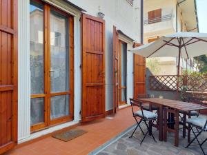 a patio with a wooden table and an umbrella at APPARTAMENTO CALETTA 2 in Castiglioncello