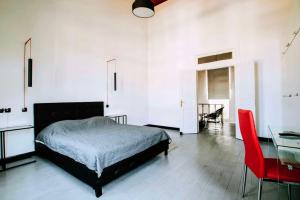 a bedroom with a bed and a table and a red chair at The Pitoulis Mansion in Igoumenitsa