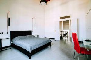 1 dormitorio con cama, mesa y silla roja en The Pitoulis Mansion, en Igoumenitsa