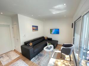 a living room with a black couch and a table at Rita Villas in Ulcinj