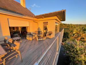 a house with a wooden deck with chairs on it at Maison des Coteaux blancs in Chaudefonds-sur-Layon