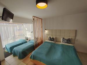 a bedroom with two beds and a flat screen tv at Bungalow Kapitański in Jastrzębia Góra