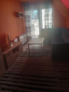 a living room with a table and a couch at Uroczy apartament in Krakow