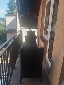 a balcony with two chairs and a window at Uroczy apartament in Kraków