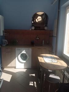 a kitchen with a washing machine and a table at Uroczy apartament in Krakow