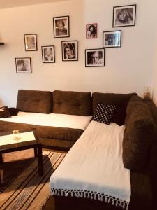 ein Wohnzimmer mit Sofa und Bildern an der Wand in der Unterkunft Poetry Apartment in Skopje