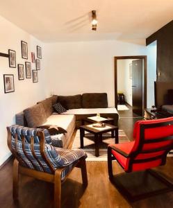 ein Wohnzimmer mit einem Sofa und einem Stuhl in der Unterkunft Poetry Apartment in Skopje