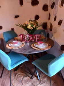 een tafel met een bord dat liefde met blauwe stoelen leest bij Romantic Casa Rural La Molinera in Santa Lucía