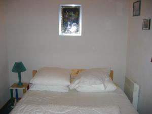 a bed with two pillows and a picture on the wall at Appartement Le Biot, 3 pièces, 6 personnes - FR-1-573-41 in Bonnevaux
