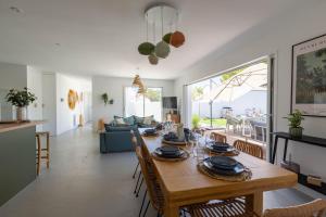 - une salle à manger et un salon avec une table et des chaises dans l'établissement Magnifique Récente Villa de charme avec piscine, au Bois-Plage-en-Ré