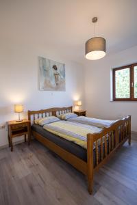 a bedroom with a wooden bed and two night stands at Bela Vista 4 Rustikales Appartement in Volosko