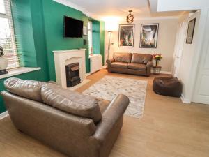 a living room with a couch and a fireplace at The Grooms in Lydney