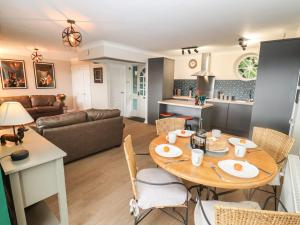 a kitchen and living room with a table and chairs at The Grooms in Lydney