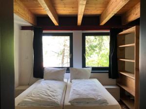 2 Betten in einem kleinen Zimmer mit 2 Fenstern in der Unterkunft FLATS 2 RENT in Imst