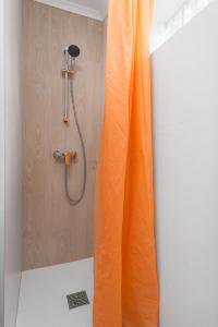 a shower with an orange curtain in a bathroom at Bungalow Kapitański in Jastrzębia Góra +28 photos