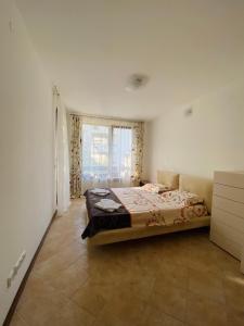 a bedroom with a bed and a large window at La Terraza del Oasis in Lozenets
