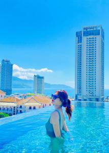 a young girl in a swimming pool with a city at Duke Casa Apartment in Da Nang