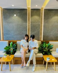a man and a woman sitting on a bench at Duke Casa Apartment in Da Nang +24 photos