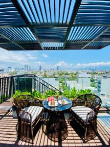 a patio with a table and chairs on a balcony at Duke Casa Apartment in Da Nang