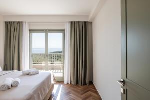 a hotel room with a bed and a large window at Helia All Seasons Apartments in Astris
