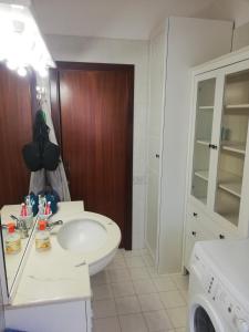 een badkamer met een wastafel en een wasmachine bij CASA SIMONE in Porto San Giorgio