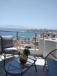 a balcony with a table and chairs and the ocean at Beautiful Sarandë in Sarandë