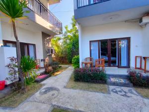 a house with a palm tree and a patio at Bali Yogi in Amed