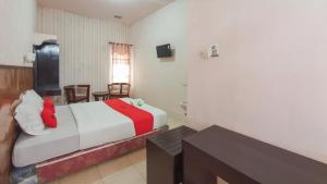 a bedroom with a bed and a table in a room at RedDoorz At Pujon Malang in Batu