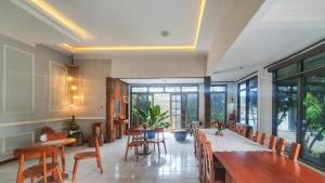 a dining room with a long table and chairs at RedDoorz At Pujon Malang in Batu