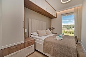 1 dormitorio con 1 cama, TV y ventana en Porto Mare BlueApart Mechelinki, en Mechelinki