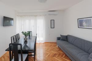 salon z kanapą i stołem w obiekcie Buena Vida Apartman w mieście Zadar